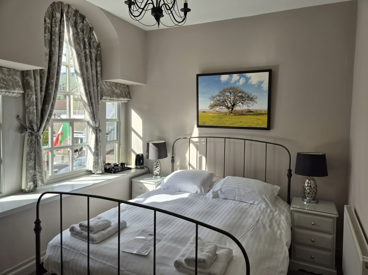 A cosy double room at The Dragon Inn with exposed beams and brass bedstead